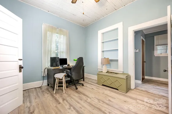 a living room with furniture and a dining table next to a window
