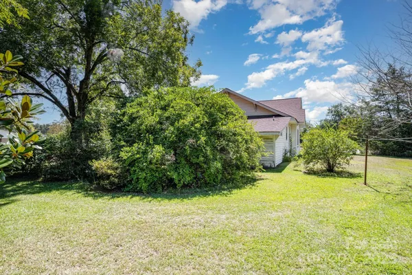 a view of a chair and table in backyard of the house