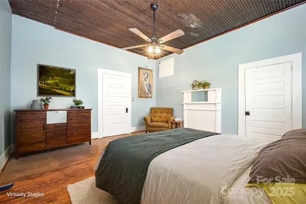 a bedroom with a bed and a flat tv screen on dresser