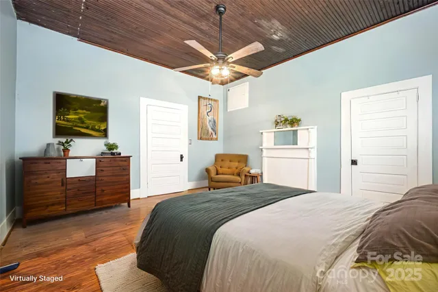 a bedroom with a bed and a flat tv screen on dresser