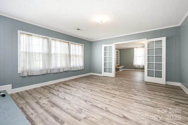 a view of empty room with wooden floor and fan