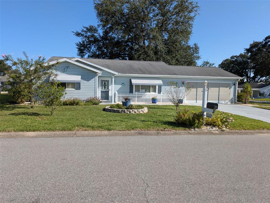 front view of house with a yard and potted plants