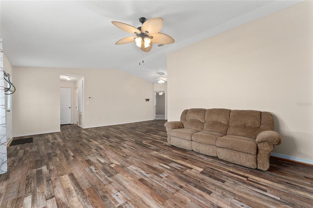 9499 Southeast 174th Loop Summerfield, FL 34491 - Photo 15 of 46 a living room with furniture a chandelier and a couch