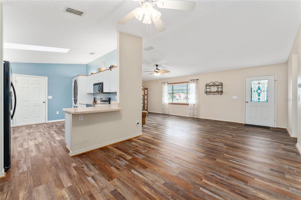 9499 Southeast 174th Loop Summerfield, FL 34491 - Photo 20 of 46 a view of kitchen and hall with wooden floor