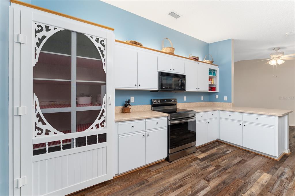 9499 Southeast 174th Loop Summerfield, FL 34491 - Photo 22 of 46 a kitchen with stainless steel appliances a stove a microwave and cabinets
