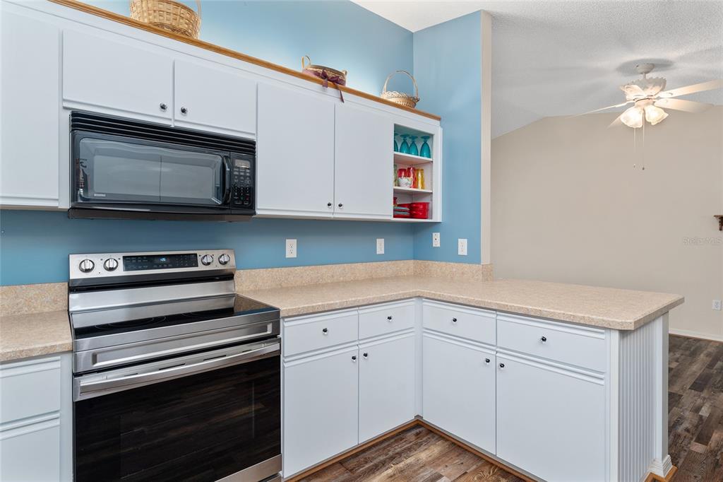 9499 Southeast 174th Loop Summerfield, FL 34491 - Photo 23 of 46 a kitchen with granite countertop cabinets stainless steel appliances and wooden floor