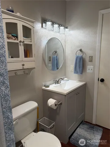 a bathroom with a toilet a sink and a mirror