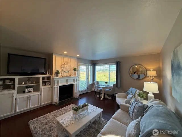 a living room with furniture a flat screen tv and kitchen view