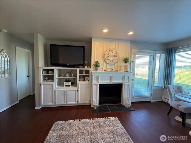 a living room with furniture a flat screen tv and a fireplace