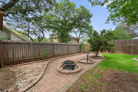 a backyard of a house with fire pit and outdoor seating