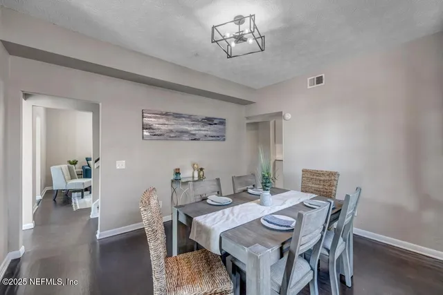 a view of a dining room with furniture wooden floor and a chandelier