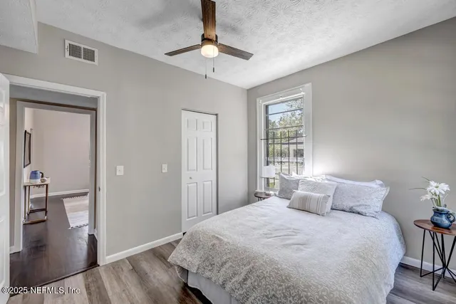 a bedroom with a bed and a table with wooden floor