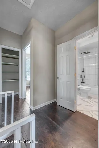 an empty room with wooden floor door and windows