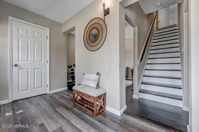 a view of entryway with wooden floor and front door