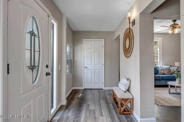 a view of a hallway with furniture and wooden floor