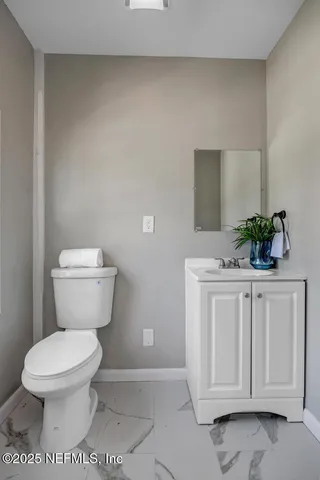 a bathroom with a toilet a sink and a potted plant