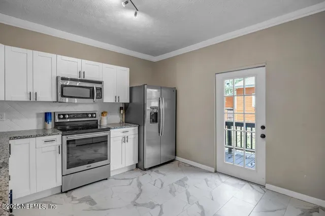 a kitchen with stainless steel appliances granite countertop a stove a sink and a refrigerator