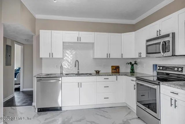 a kitchen with stainless steel appliances granite countertop a stove a sink and a refrigerator