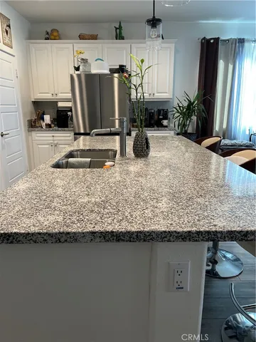 a view of a kitchen with kitchen island granite countertop sink and a granite counter tops