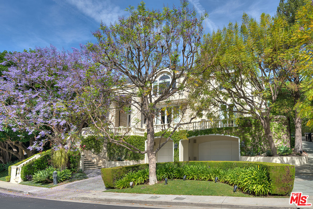 a front view of a house with a yard and tree s