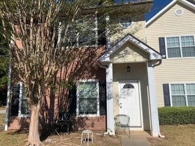 a front view of a house with a garden