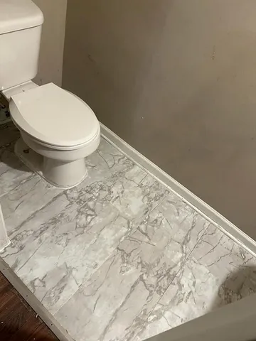 a white toilet sitting next to a sink