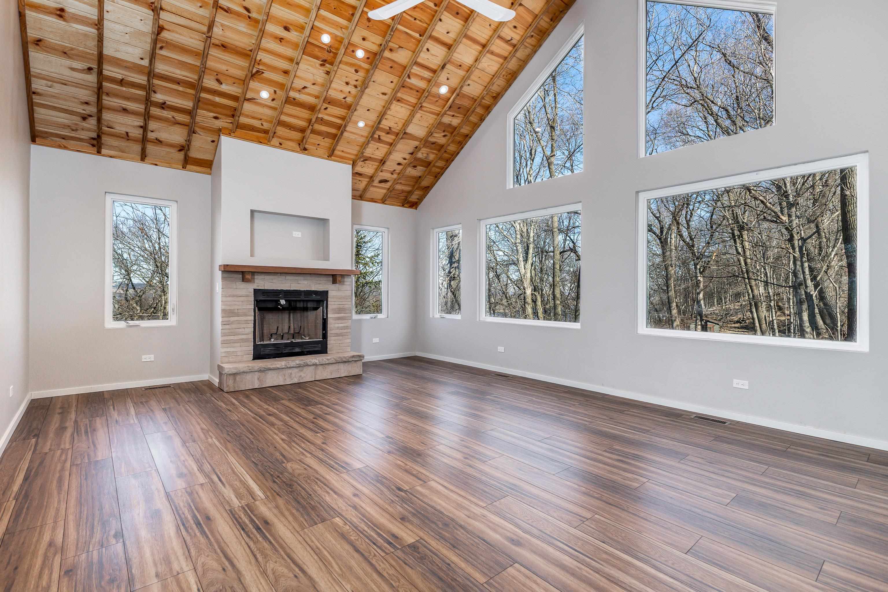 4785 South River Road Hanover, IL 61041 - Photo 5 of 46 a view of an empty room with wooden floor fireplace and a window