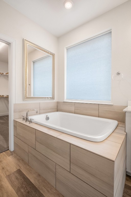 748 Hazy Hills Loop Dripping Springs, TX 78620 - Photo 29 of 40 Bathroom featuring light wood-style flooring, a bath, and a walk in closet
