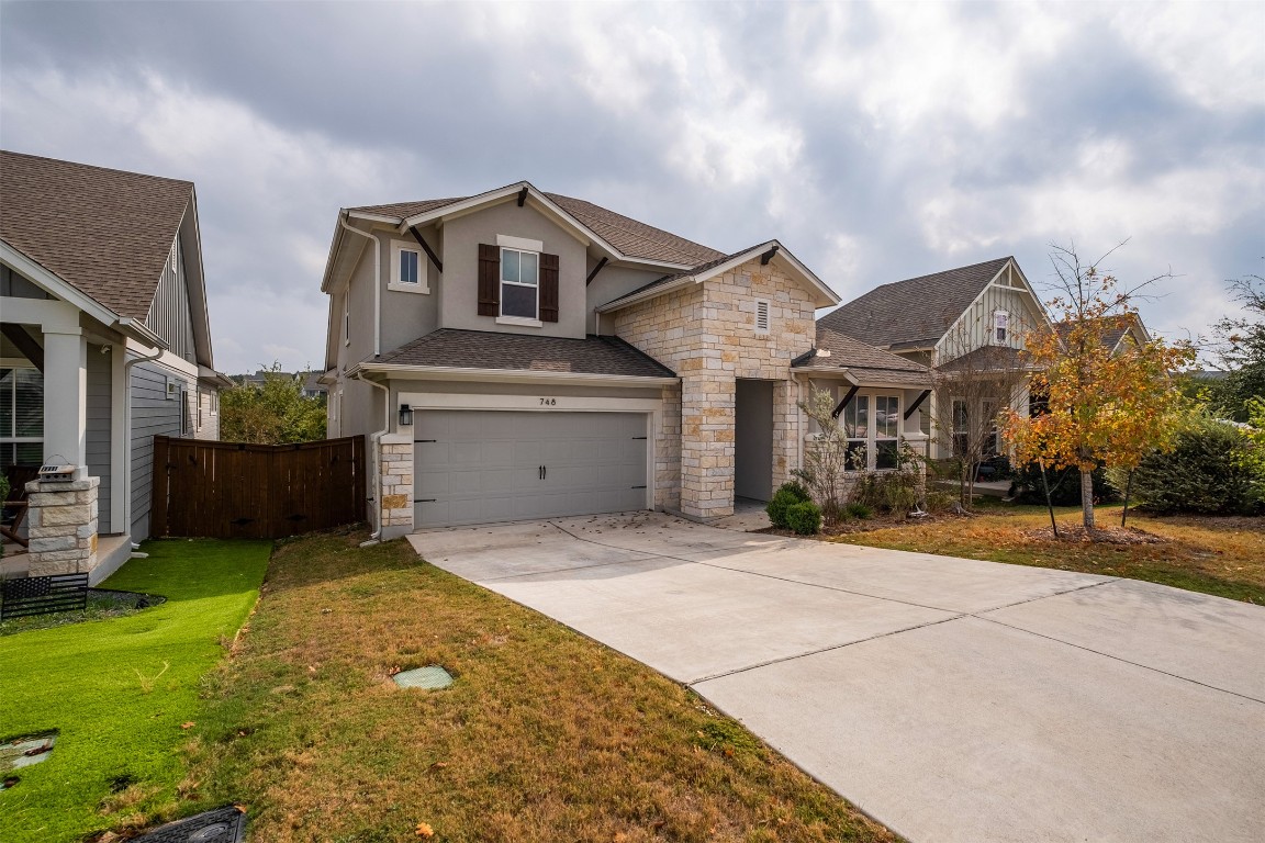 748 Hazy Hills Loop Dripping Springs, TX 78620 - Photo 40 of 40 View of front of house featuring stone siding, driveway, a garage, stucco siding, and roof with shingles