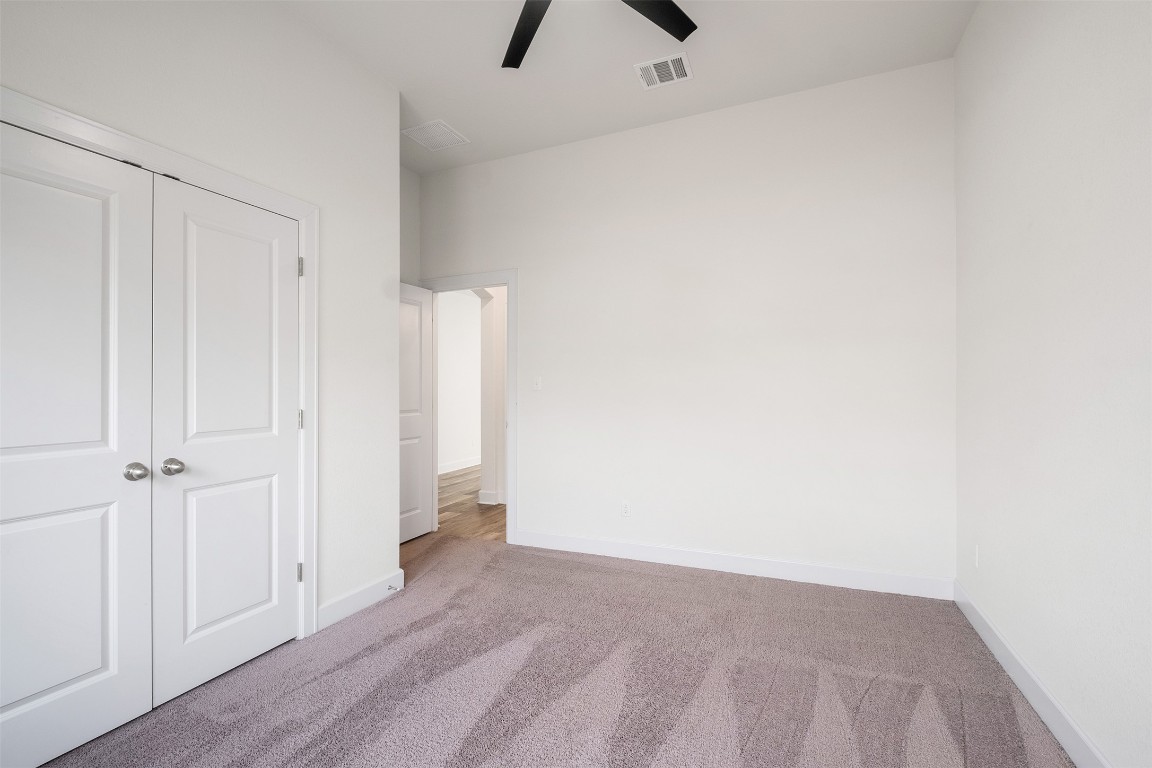 748 Hazy Hills Loop Dripping Springs, TX 78620 - Photo 5 of 40 Unfurnished bedroom with carpet floors, a closet, and ceiling fan