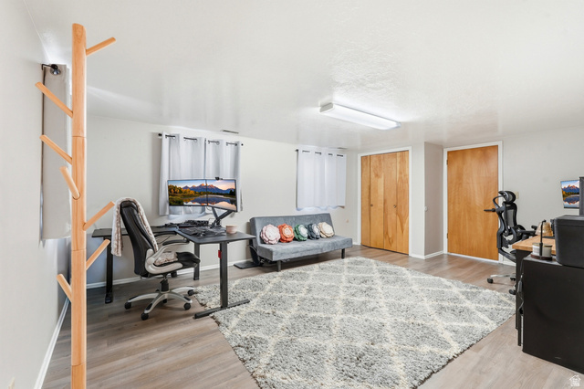 270 East 700 North Logan, UT 84321 - Photo 25 of 42 Versatile room featuring light wood-finish flooring, two wood-paneled doors, and two windows with white curtains