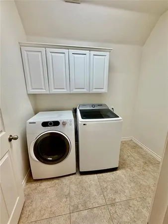 a utility room with sink dryer and washer