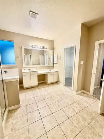 a large white room with a large mirror and cabinets