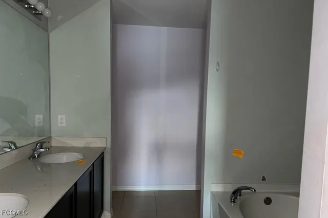 a bathroom with a tub sink and mirror