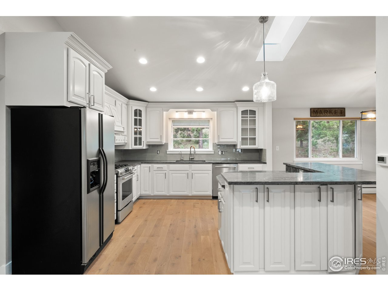 1073 Deer Trail Road Boulder, CO 80302 - Photo 9 of 32 a kitchen with stainless steel appliances granite countertop a refrigerator a sink dishwasher a stove and white countertops with wooden floor