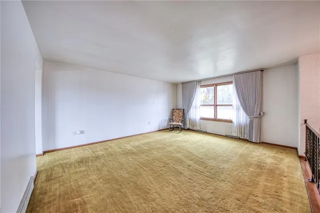 an empty room with a fireplace and windows