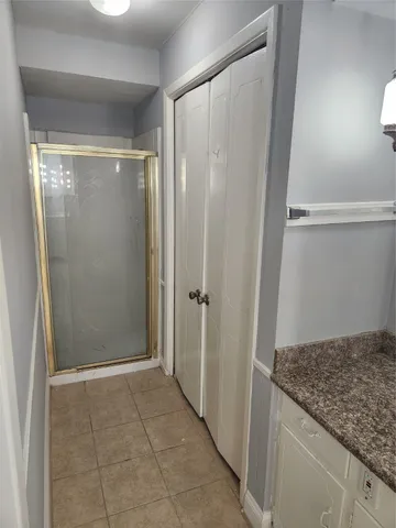 a bathroom with a granite countertop shower and a sink