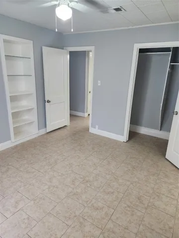 an empty room with closet and chandelier fan