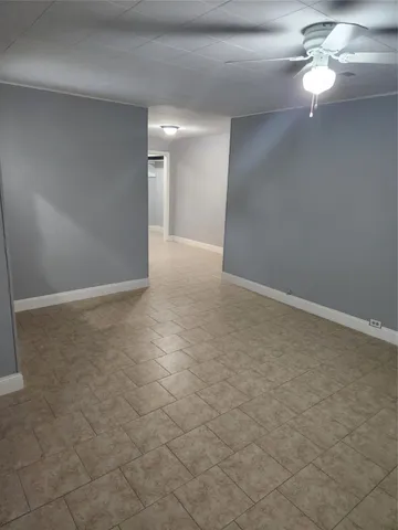 a view of an empty room with a chandelier fan