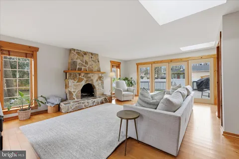 a living room with furniture a fireplace and a floor to ceiling window