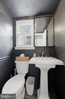 a bathroom with a toilet a sink and mirror