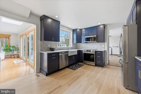 a large kitchen with stainless steel appliances granite countertop a stove refrigerator and a microwave oven