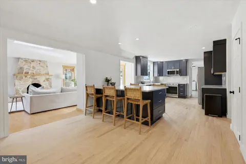 a living room with stainless steel appliances kitchen island granite countertop furniture and a view of kitchen