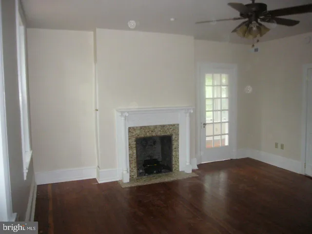 an empty room with windows and fireplace