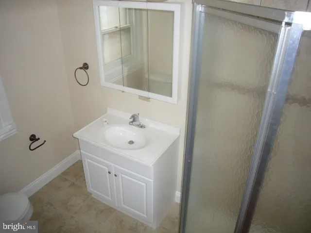 a bathroom with a sink and mirror with toilet