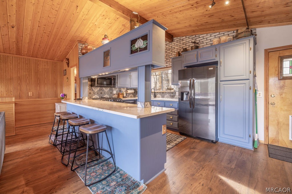 1179 Ridge Road Fawnskin, CA 92333 - Photo 18 of 43 a kitchen with stainless steel appliances a refrigerator and wooden cabinets
