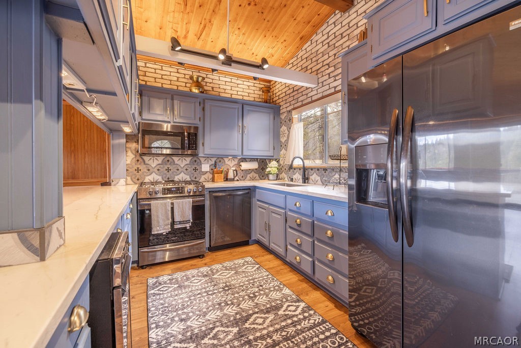 1179 Ridge Road Fawnskin, CA 92333 - Photo 19 of 43 a kitchen with stainless steel appliances granite countertop a refrigerator a stove and a sink with wooden cabinets
