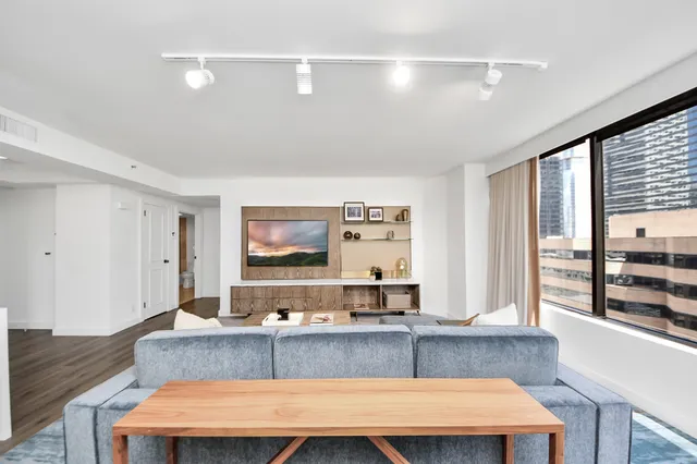 a living room with stainless steel appliances kitchen island granite countertop furniture and a large window
