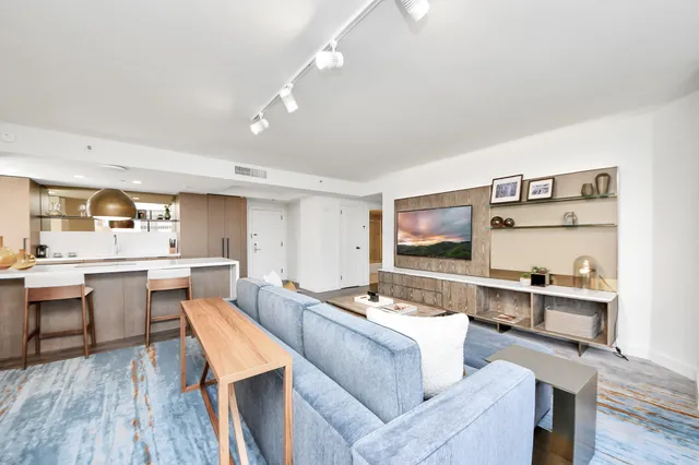 a living room with stainless steel appliances kitchen island granite countertop furniture and a kitchen view