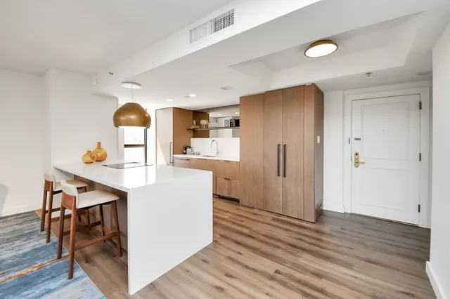 a kitchen with stainless steel appliances a refrigerator and a wooden floor